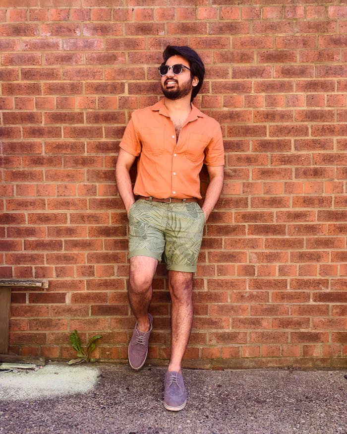 The Art of Drawing Readers In: Your attractive post title goes here Casual fashion portrait of a man in summer attire against a brick wall.